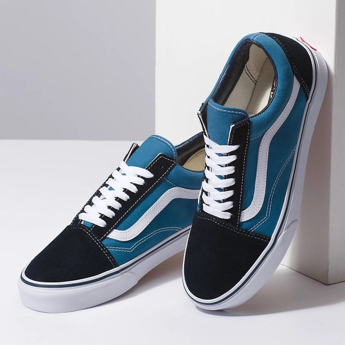 Vans Old Skool sneakers in teal blue and black with white side stripe, laces, and rubber sole, angled side view.