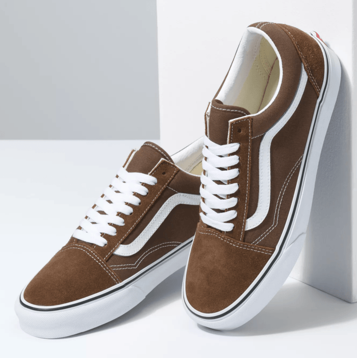 Vans Old Skool sneakers in brown suede with white side stripe, laces, and rubber outsole, front angle view.