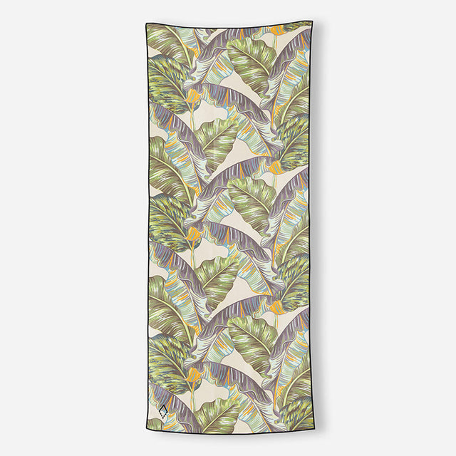 Nomadix Original Towel with tropical leaf pattern in green, beige, and yellow, lightweight microfiber material, front view.