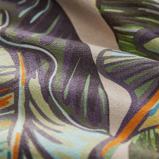 Nomadix Original Towel with colorful abstract design featuring green, purple, orange, and beige details, close-up view.