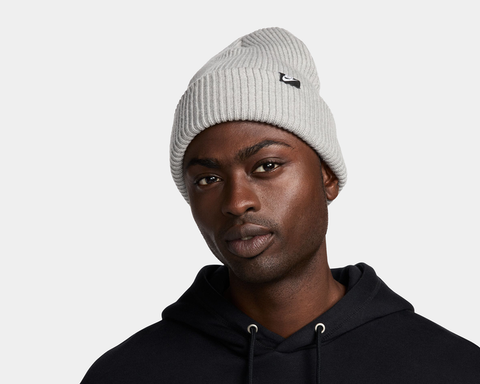 Nike Peak beanie in light gray ribbed knit fabric with embroidered logo patch, front view.