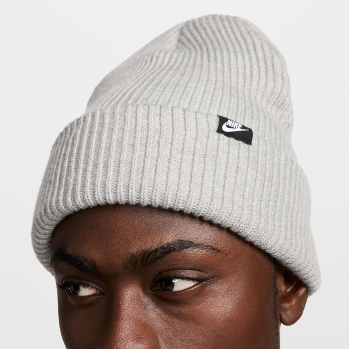 Nike Peak beanie in light gray with ribbed knit design and black logo tag, front view.