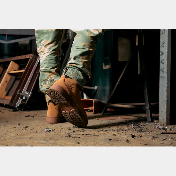 DC WorkCrew Peary TR Work Waterproof Comp Toe Boot in tan leather with rugged outsole, worn in workshop setting.