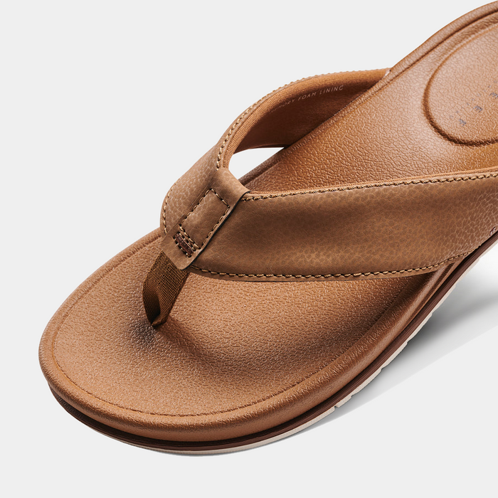 Reef Phantom Bronzer sandals in brown synthetic leather with cushioned footbed and stitch detailing, close-up top view.
