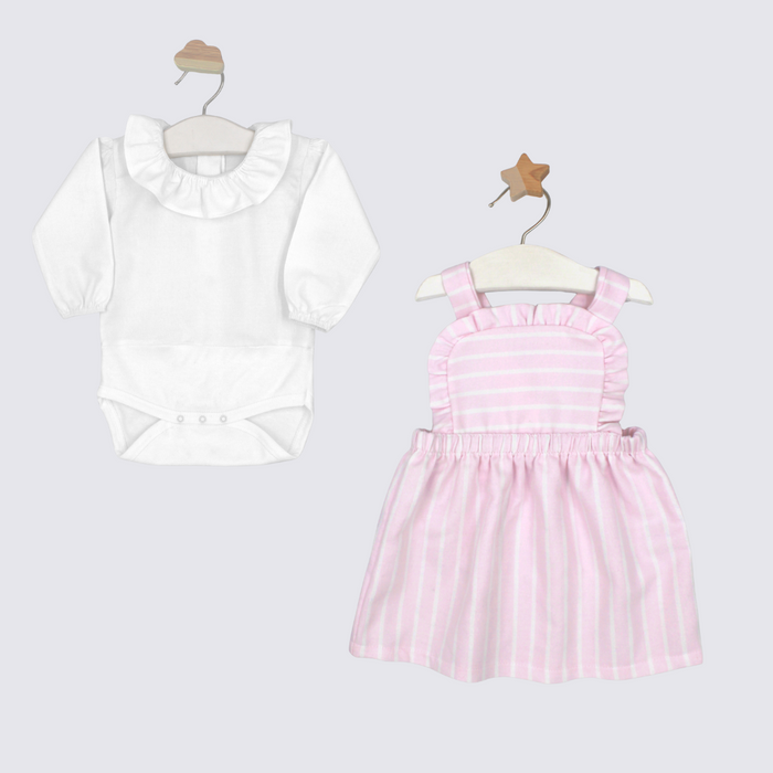 White blouse with ruffled collar and pink striped dress on hangers against a light gray background