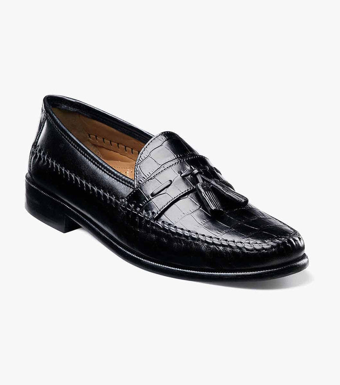 Florsheim Pisa loafers in black leather with crocodile-embossed texture, tassel detailing, and stitched accents, side-front view.