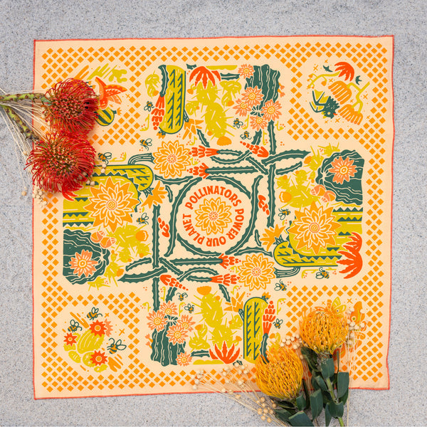 Bandits "Prickly Pollinators" bandana with vibrant floral and cactus illustrations in yellow, green, and orange, top view.