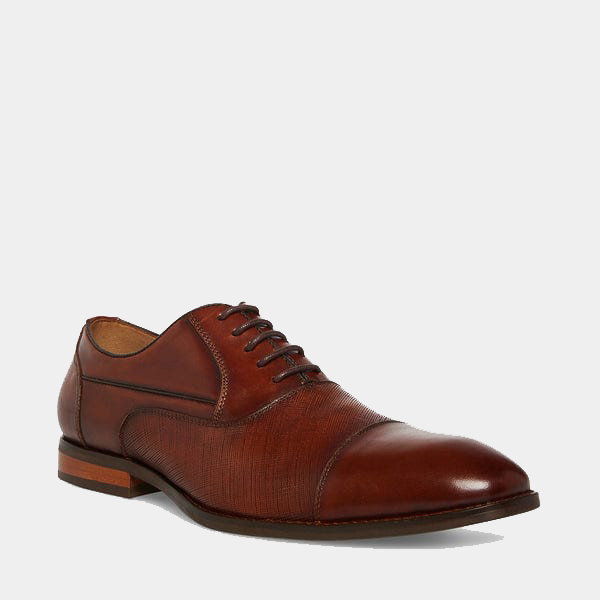 Steve Madden Proctor dress shoes in rich brown leather with textured detailing and cap-toe design, angled side view.