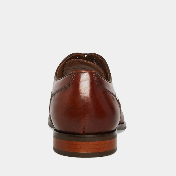 Steve Madden Proctor dress shoes in polished brown leather with stacked heel, back view showing heel counter.