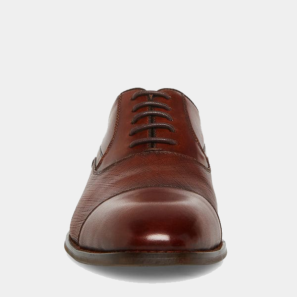 Steve Madden Proctor dress shoes in polished brown leather and textured detailing, front view showing laces and rounded toe.