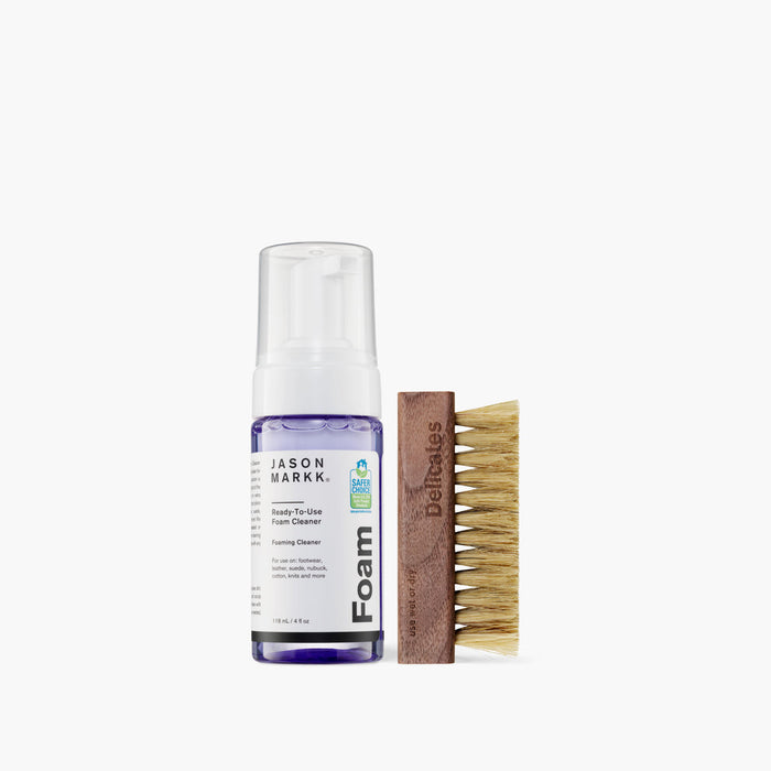Jason Markk Quick Clean Kit featuring ready-to-use foam cleaner in a purple and white bottle and a wooden brush with natural bristles, front view.
