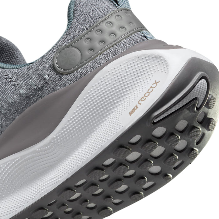 Nike React Infinity Run 4 running shoe outsole with multi-textured tread, white and gray midsole, and light gray upper, side view.