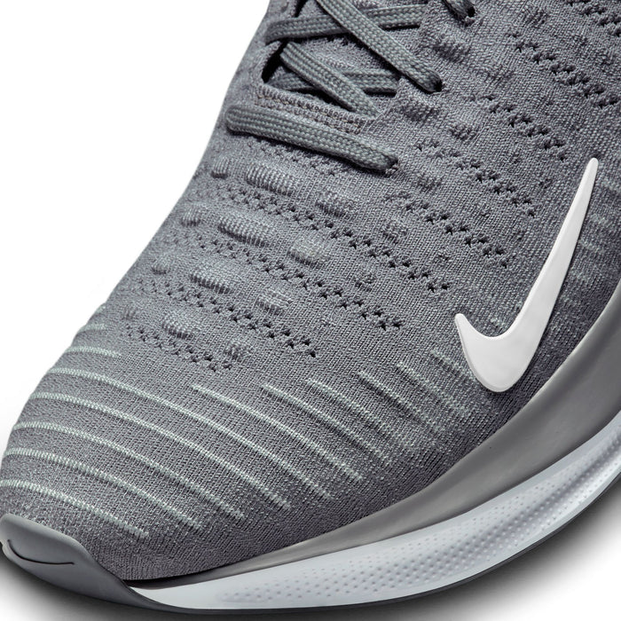 Nike React Infinity Run 4 running shoes with a gray knit upper, breathable detailing, and white swoosh logo, close-up of toe box.