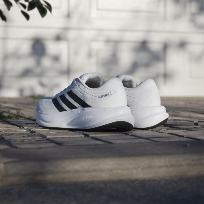 Adidas Response 2 shoes in white with black stripes, featuring a textured midsole and Cloudfoam cushioning, back angled outdoor view.