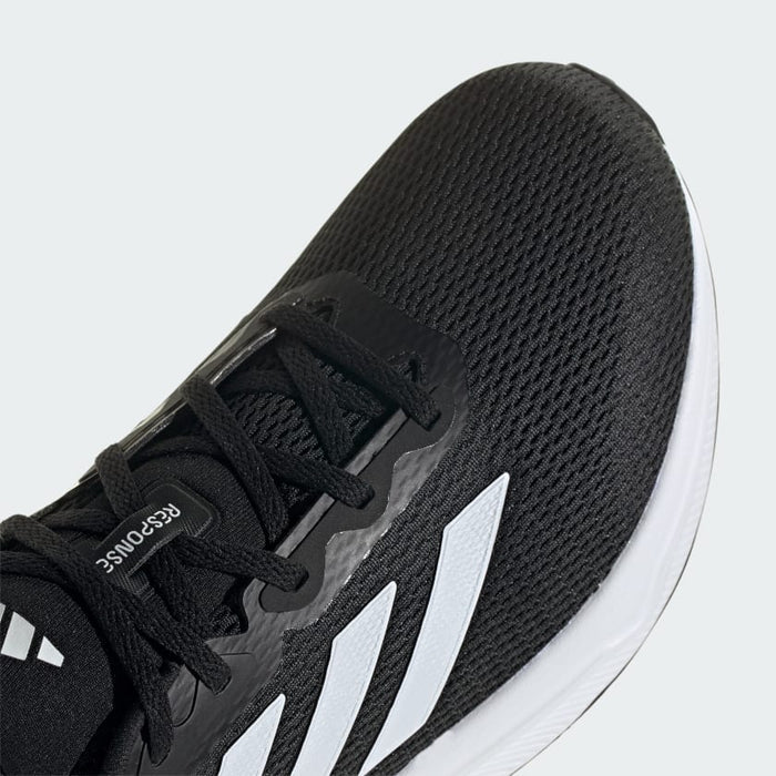 Adidas Response running shoes with black mesh upper, white three-stripe detailing, and cushioned sole, close-up top view.