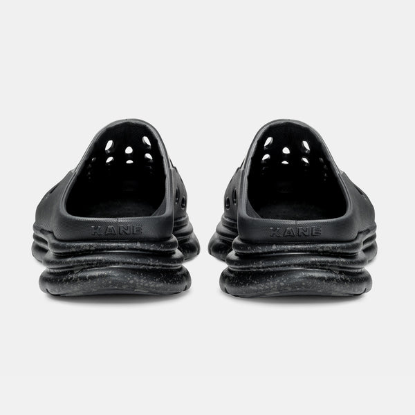 Kane Revive OB recovery shoes in black with perforated design and cushioned outsole, back view.