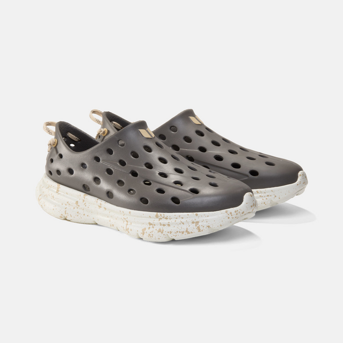 Dark gray shoes with white soles on a light gray background