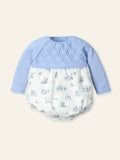 Baby outfit with blue top and patterned bottom on a beige background
