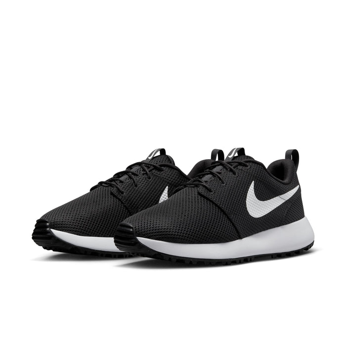 Nike Roshe Golf Next Nature golf shoes in black with breathable mesh upper, white midsoles, and rubber outsoles, front angled view.