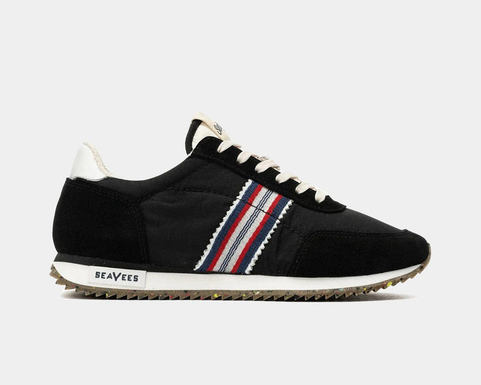 SeaVees Royal Runner sneakers in black with red, white, and blue striped side detailing and textured gum sole, side view.