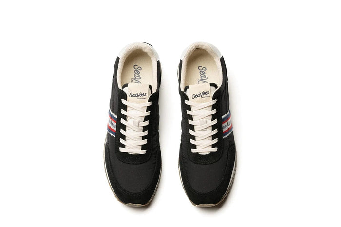 SeaVees Royal Runner sneakers in black with white laces, red and blue striped side accents, top view.