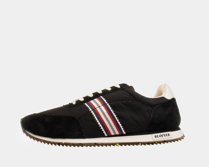 SeaVees Royal Runner sneakers in black with suede and nylon upper, striped red and blue side detail, and white outsole, side view.