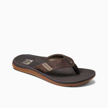 Reef Santa Anna flip-flops with brown synthetic leather straps, textured black footbed, and tan rubber outsole, angled side view.