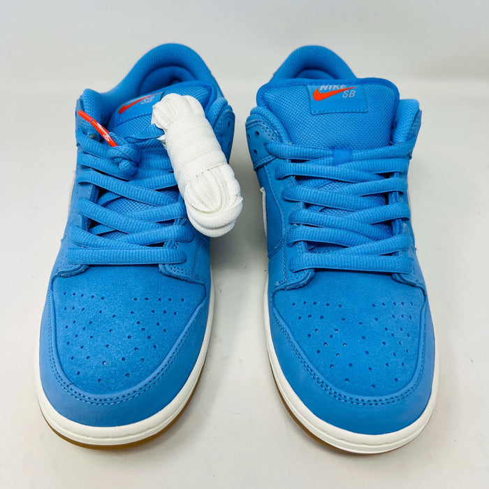 The Nike SB Dunk Low Pro University Blue Gum sneaker, featuring a white swoosh, laces, midsole, and gum-colored outsole, is placed on a brown shoebox with an orange swoosh against a plain white background.