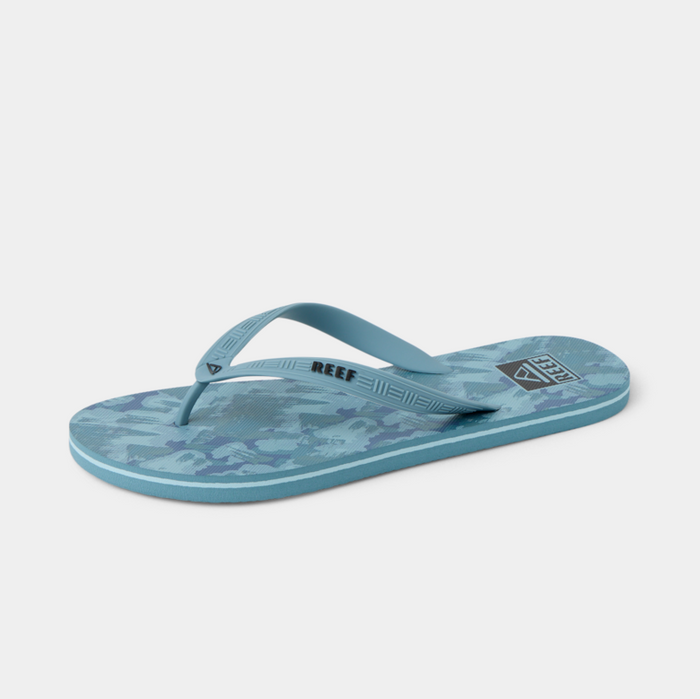 Reef Seaside Prints flip flops in blue with patterned footbed and light blue straps, side view.