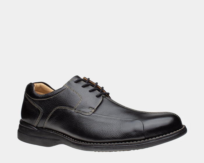 Johnston & Murphy Shuler Bicycle shoes in black leather with textured upper, contrast stitching, and rounded toe box, side view.
