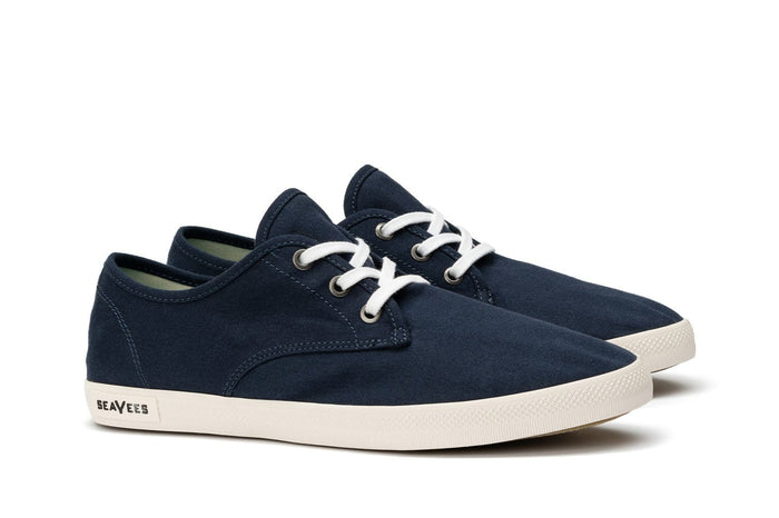 SeaVees Sixty Six sneakers in navy blue canvas with white laces and textured off-white rubber outsole, angled side view.