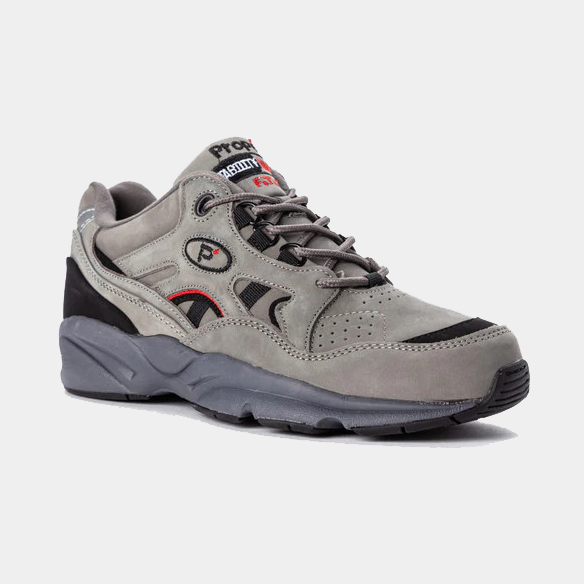 Propét Stability Walker shoes in gray suede with black and red accents, perforated upper, and durable outsole, angled side view.