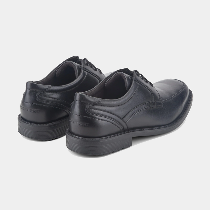 Rockport Style Leader 2 Apron Toe dress shoes in black leather with apron toe design and embossed branding, back angle view.