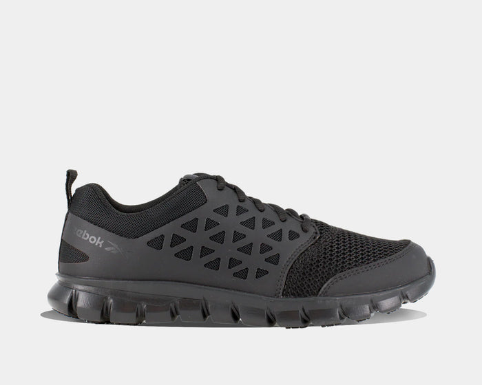 Reebok Work Sublite Cushion Work Soft Toe work shoes in black with mesh upper and geometric overlays, side view.