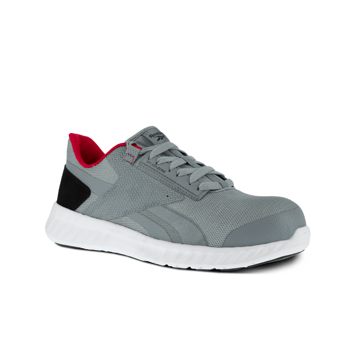 Reebok Work Sublite Legend Work shoes in gray with black accents, red interior, and white lightweight sole, angled side view.