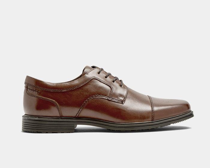Rockport Taylor Cap Toe dress shoes in brown leather with cap toe detail and durable outsole, side view.