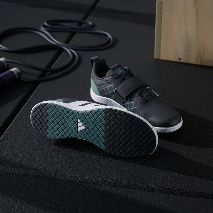 Adidas THE TOTAL 2 training shoes in black with teal accents, secure strap design, and durable rubber outsole, angled side and bottom view.