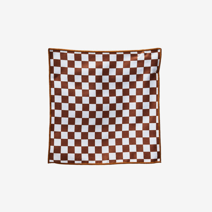 Nomadix Tiny Towel in brown and white checkered pattern made of soft, absorbent material, front view.