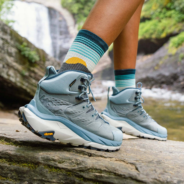 "Feetures Trail Max Cushion Mini Crew Sock in teal, yellow, and white with cushioned design and breathable fabric, worn outdoors"