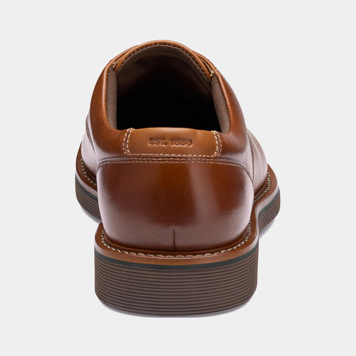 "Johnston & Murphy Tyson Plain Toe dress shoes in tan leather with contrast stitching and striped rubber sole, back view"
