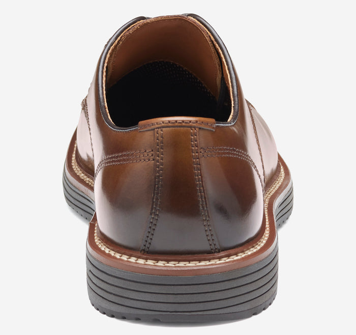 Johnston & Murphy Upton Cap Toe dress shoes in brown leather with stitched detailing and layered sole, back view.
