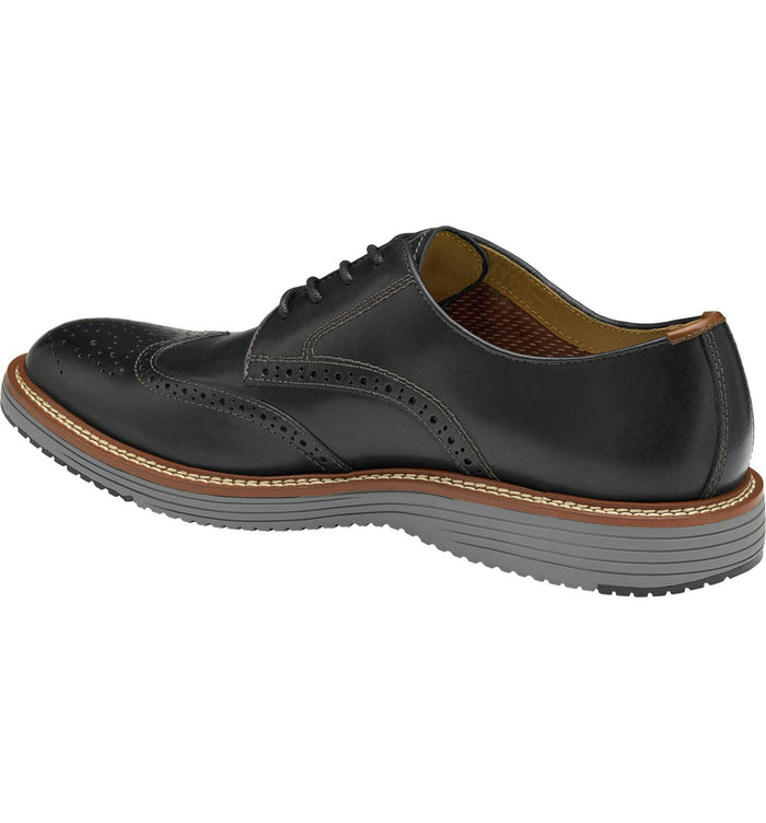 Johnston & Murphy Upton Wingtip shoes in black leather with brogue detailing and stitched welt, side angled view.