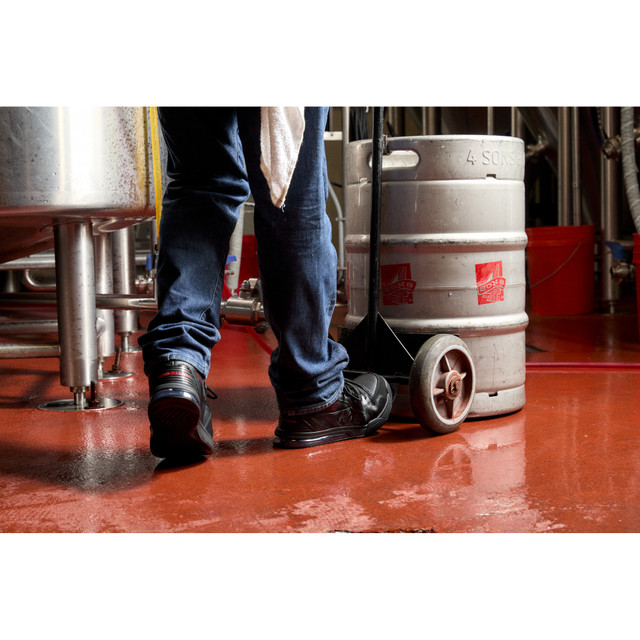 DC WorkCrew Versatile Work Hi Top Comp Toe work shoes in black with a protective composite toe and high-top design, worn by worker on red floor.
