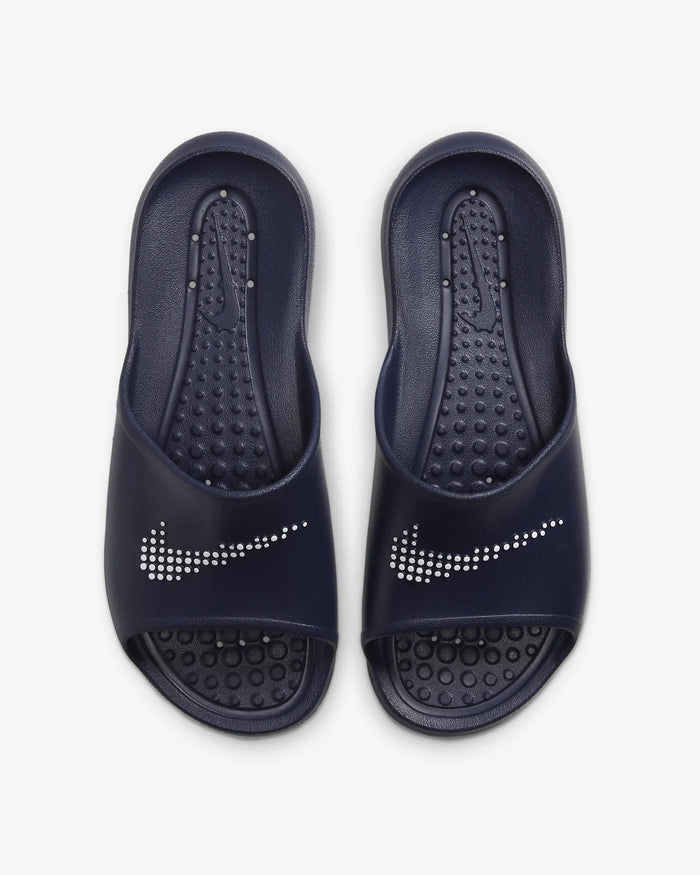 Nike Victori One Shower sandals in navy blue featuring textured footbed, white dotted Nike logo, and open-toe design, top view.