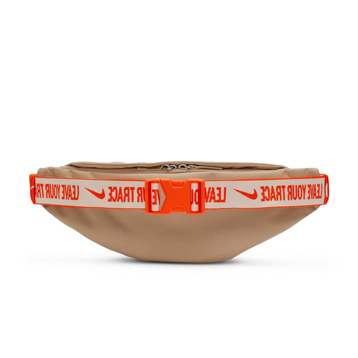 Nike Waist Pack in tan with bold orange and white adjustable strap featuring "Leave Your Trace" text and buckle closure, front view.