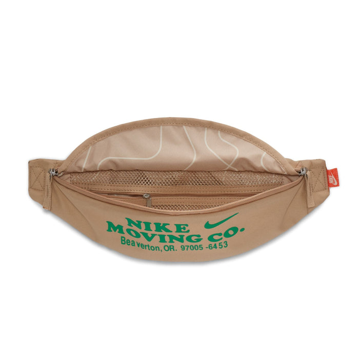 Nike Waist Pack in beige with green "Nike Moving Co." print, zippered main compartment, and internal mesh pocket, front view showing open design.