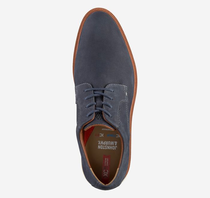 Johnston & Murphy XC+ Parker shoes in navy blue with suede upper, lace-up closure, and brown sole, top view.